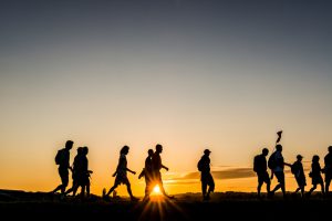 The Netherlands - Participants in a walking event walk in the first sunlight on a dike in the Netherlands.